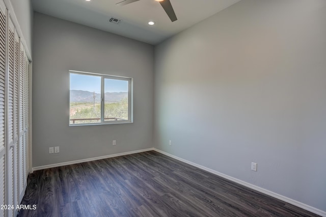 unfurnished room with ceiling fan, dark hardwood / wood-style floors, and a mountain view