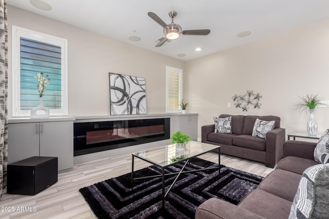 5407 S Tatum Ln, Gilbert, AZ 85298 - living room featuring light wood-style flooring, ceiling fan, a glass covered fireplace, and recessed lighting