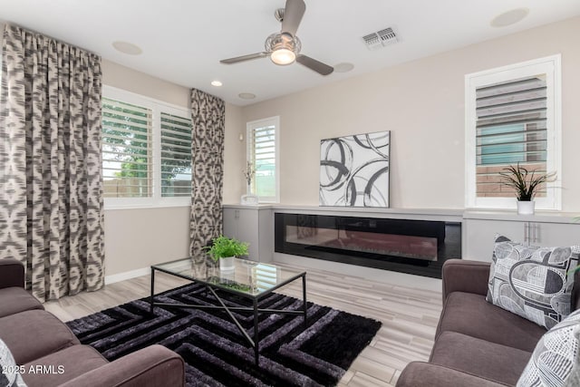 5407 S Tatum Ln, Gilbert, AZ 85298 - living room featuring a glass covered fireplace, wood finished floors, ceiling fan, baseboards, and recessed lighting