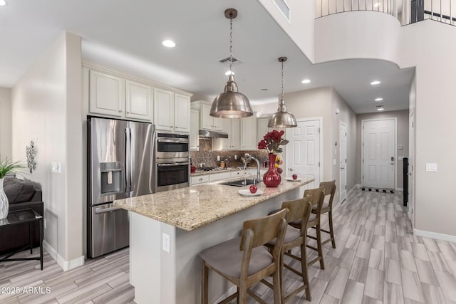 5407 S Tatum Ln, Gilbert, AZ 85298 - kitchen featuring stainless steel appliances, baseboards, a sink, wood tiled floors, and under cabinet range hood