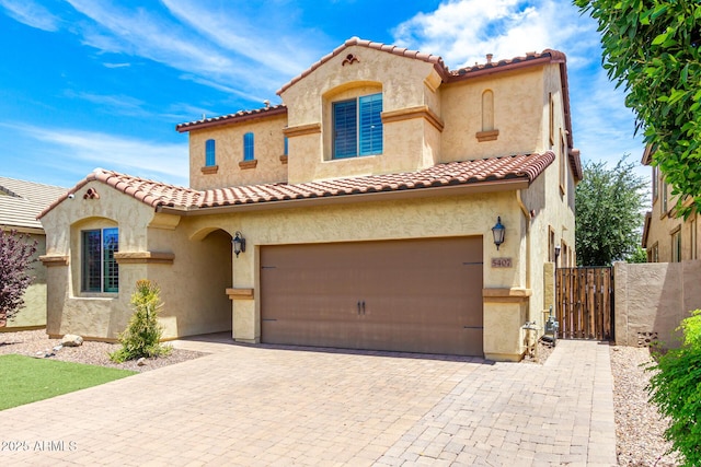 5407 S Tatum Ln, Gilbert, AZ 85298 - mediterranean / spanish home featuring stucco siding, a tiled roof, driveway, a garage, and a gate
