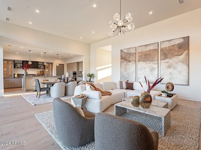 living room featuring an inviting chandelier and light hardwood / wood-style flooring