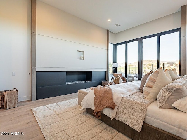 bedroom featuring a fireplace and light wood-type flooring