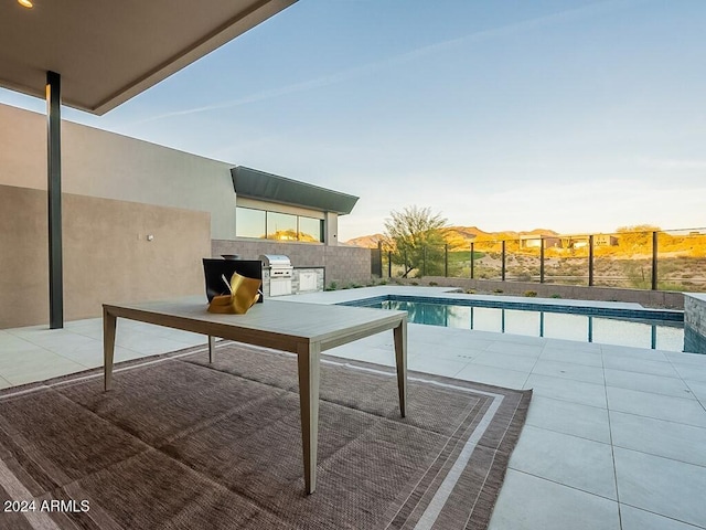 view of swimming pool featuring a patio, area for grilling, and exterior kitchen