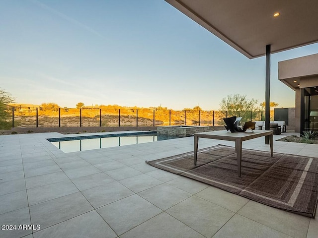 pool at dusk with a patio area