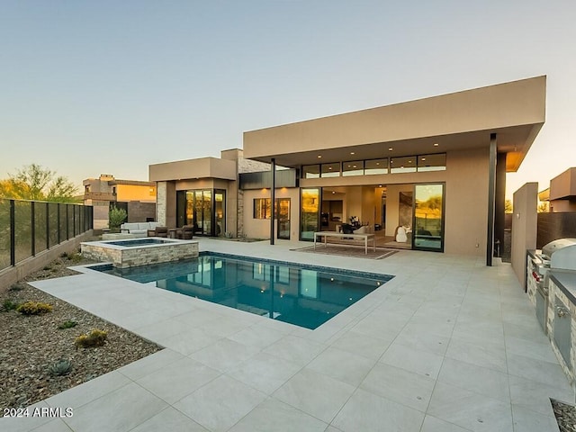 pool at dusk with an in ground hot tub, area for grilling, and a patio area