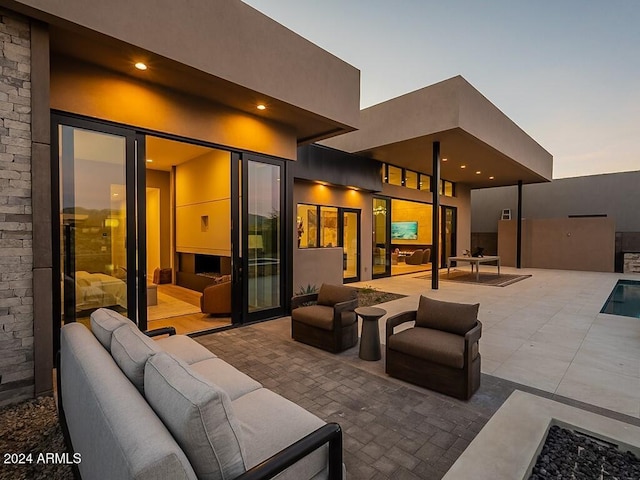 patio terrace at dusk featuring an outdoor living space