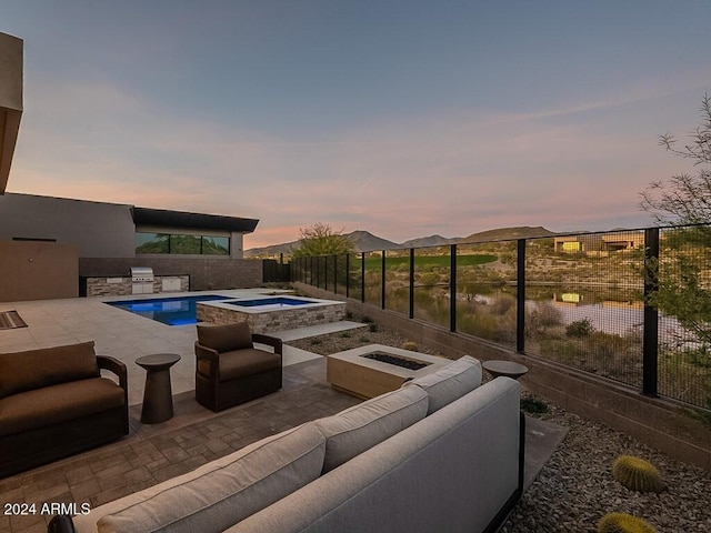 pool at dusk featuring a patio area, area for grilling, an in ground hot tub, and an outdoor hangout area