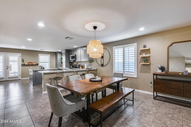 dining space featuring plenty of natural light, dark tile patterned floors, and french doors