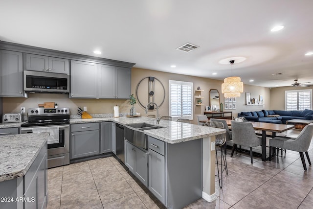 kitchen featuring appliances with stainless steel finishes, gray cabinets, ceiling fan, and pendant lighting