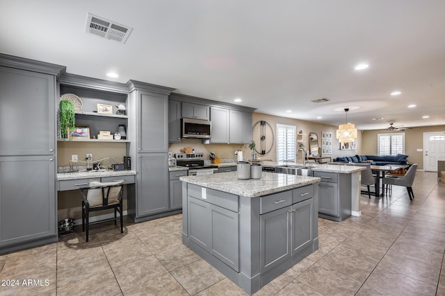 kitchen featuring ceiling fan, gray cabinets, and stainless steel appliances