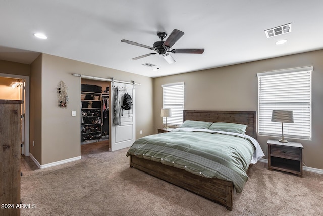 carpeted bedroom with a spacious closet, a closet, and ceiling fan