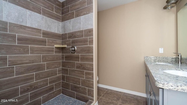 bathroom featuring a tile shower, vanity, and tile patterned floors