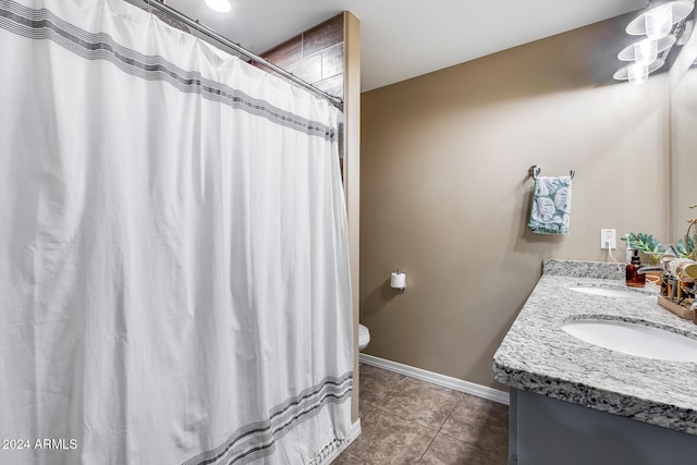 bathroom with tile patterned flooring, vanity, and toilet