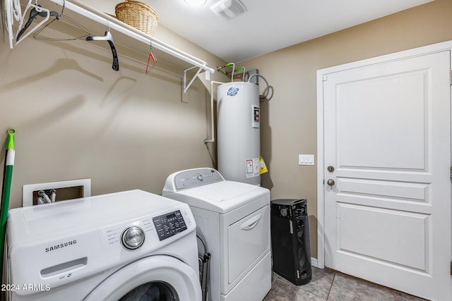 washroom with electric water heater, light tile patterned floors, and washer and dryer