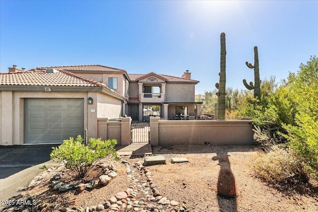 view of front of home featuring a gate, an attached garage, a chimney, stucco siding, and a fenced front yard