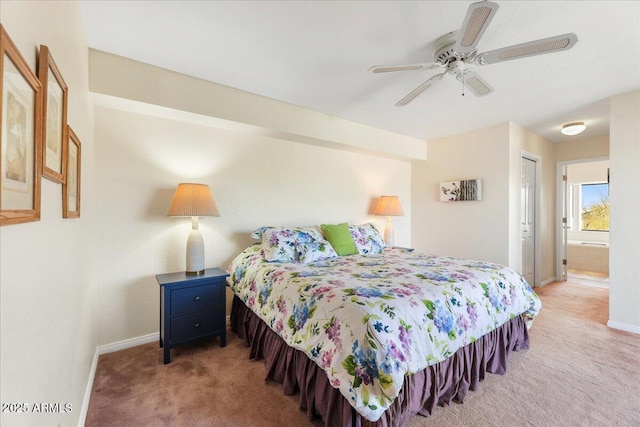 carpeted bedroom with a closet, baseboards, ceiling fan, and ensuite bathroom