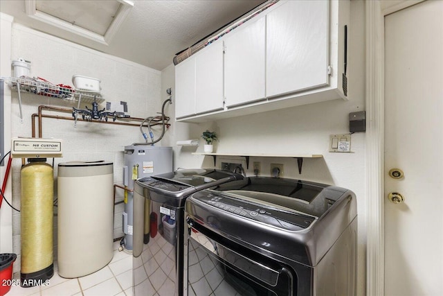 laundry area with washer and clothes dryer, water heater, cabinet space, light tile patterned floors, and attic access