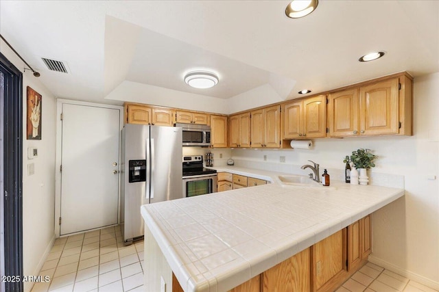 kitchen featuring visible vents, light tile patterned floors, appliances with stainless steel finishes, a peninsula, and a sink