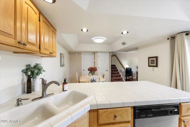 kitchen featuring stainless steel dishwasher, a peninsula, visible vents, and a sink