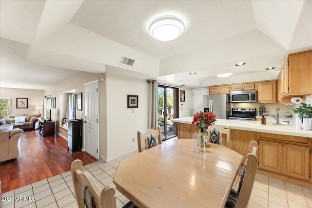 dining room with a tray ceiling, light tile patterned floors, recessed lighting, and visible vents