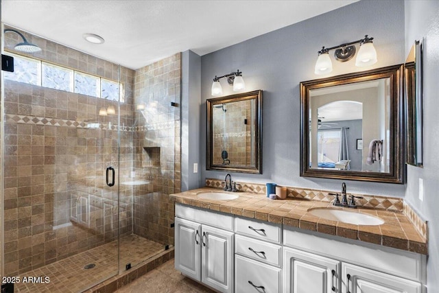 bathroom with an enclosed shower, vanity, tile patterned flooring, and ceiling fan