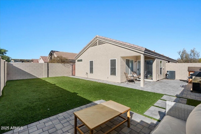 back of house featuring a yard, central AC unit, and a patio