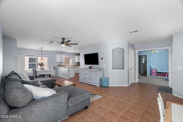 living room featuring ceiling fan and light tile patterned floors