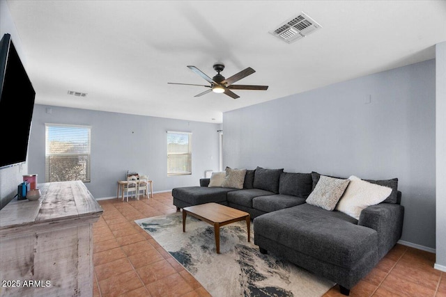 living room featuring ceiling fan, tile patterned floors, and a wealth of natural light