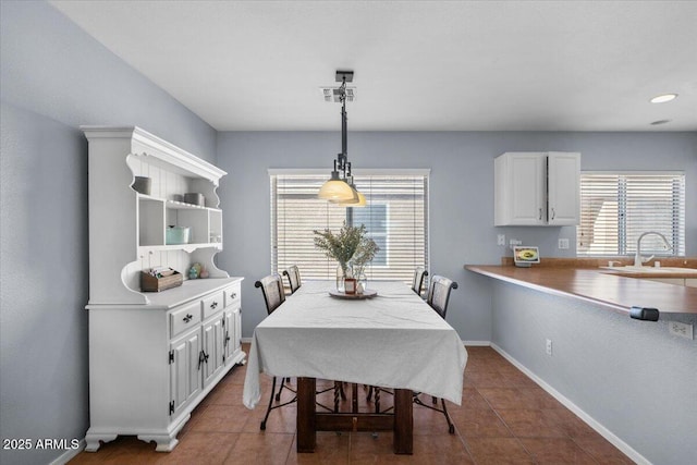 dining room featuring sink and dark tile patterned flooring