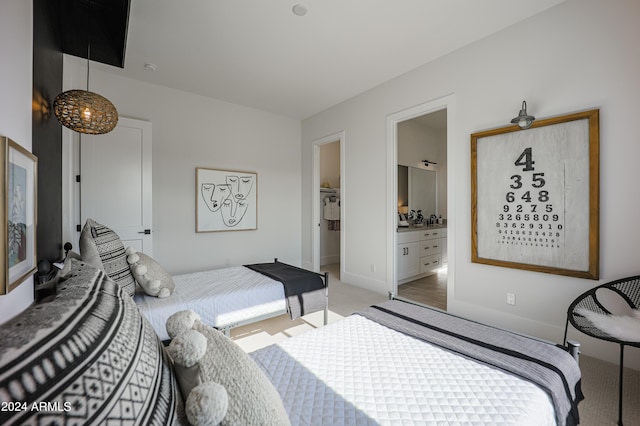 bedroom with baseboards, connected bathroom, and light colored carpet