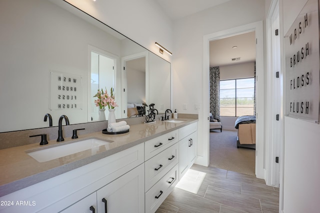 ensuite bathroom featuring a sink, double vanity, and ensuite bath