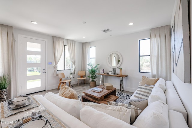 living area with baseboards, recessed lighting, visible vents, and light wood-style floors