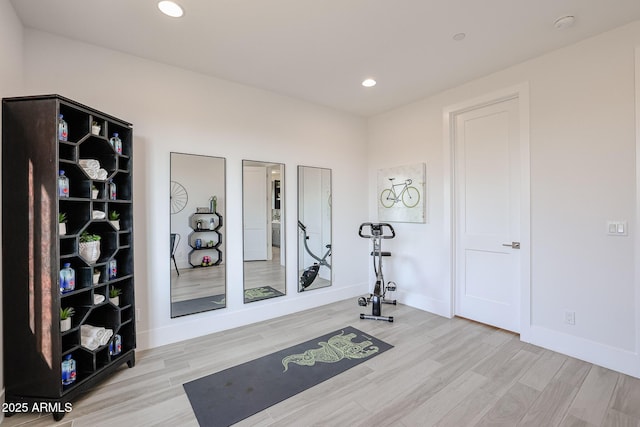 exercise room featuring light wood-style floors, baseboards, and recessed lighting