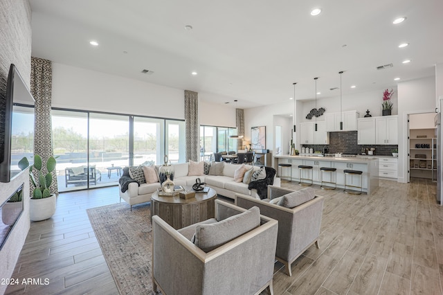 living area featuring light wood-style floors, recessed lighting, and visible vents