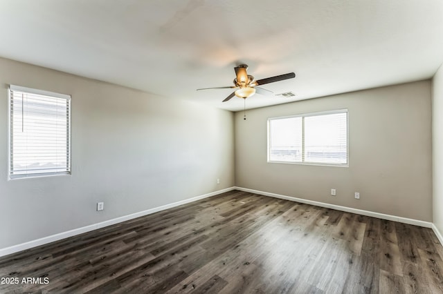 empty room with ceiling fan and dark hardwood / wood-style flooring