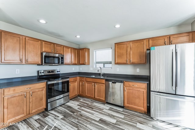 kitchen featuring wood-type flooring, stainless steel appliances, and sink