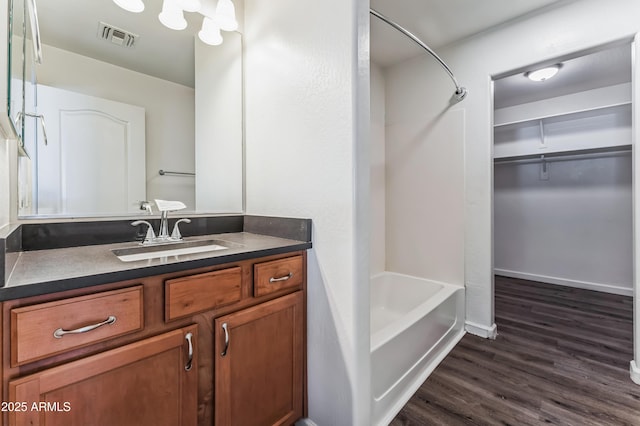 bathroom with hardwood / wood-style floors, vanity, and  shower combination