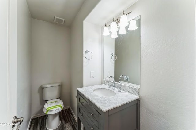 bathroom featuring vanity, hardwood / wood-style flooring, and toilet