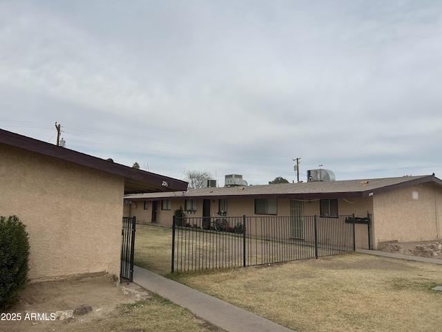 view of front of house with a front lawn, fence, and stucco siding