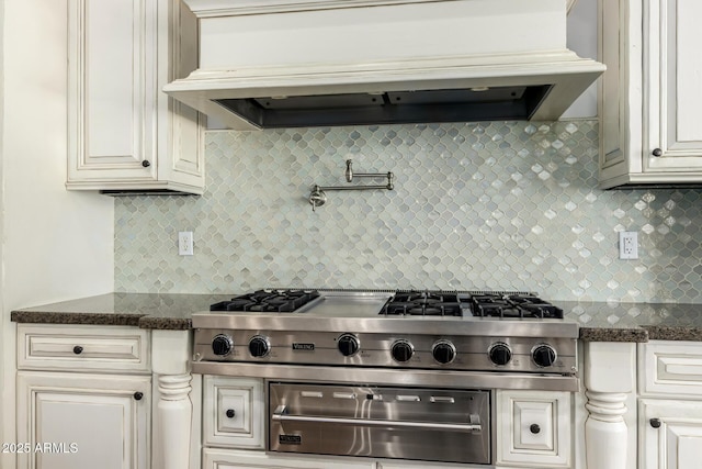kitchen featuring dark stone counters, decorative backsplash, cooktop, custom exhaust hood, and a warming drawer