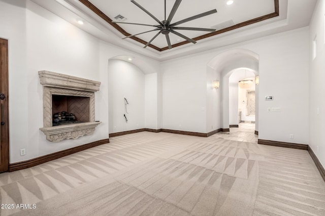 unfurnished living room featuring ceiling fan, carpet floors, arched walkways, recessed lighting, and baseboards