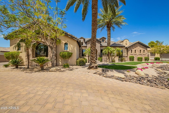 mediterranean / spanish home featuring stone siding and stucco siding