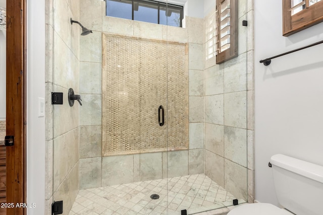 full bath featuring a stall shower and toilet