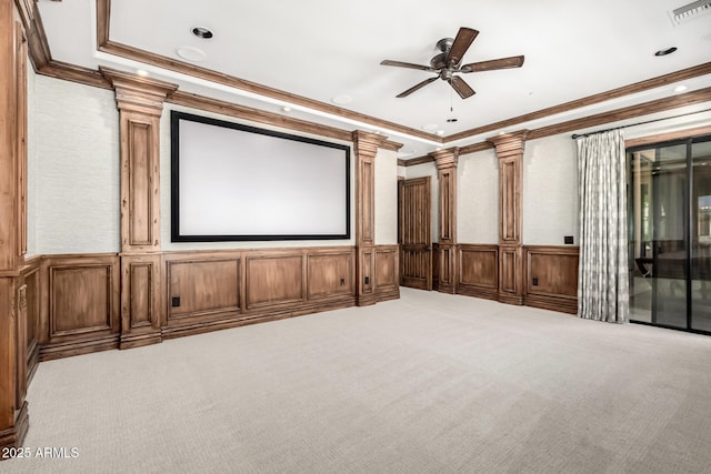 carpeted cinema with visible vents, crown molding, decorative columns, a decorative wall, and a ceiling fan