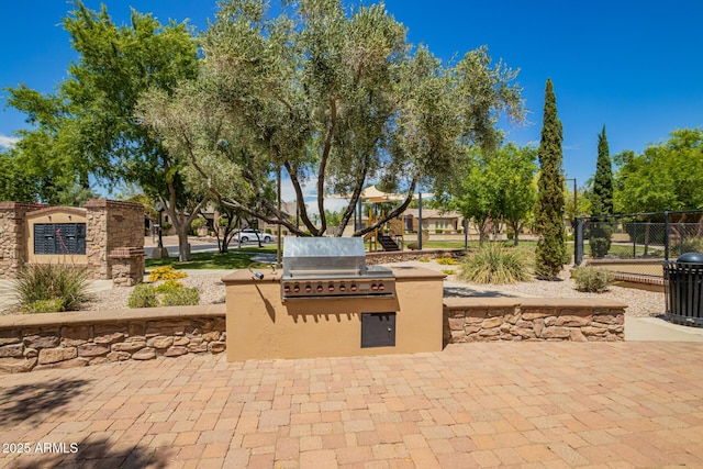 view of patio with a grill, fence, and area for grilling