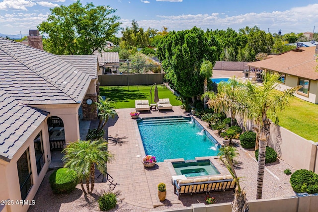 view of swimming pool with a lawn, a fenced backyard, and a pool with connected hot tub