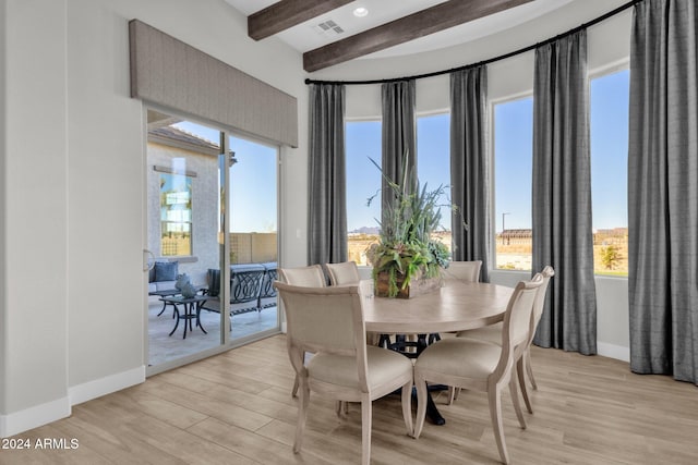 dining room featuring a wealth of natural light, light hardwood / wood-style floors, and beam ceiling