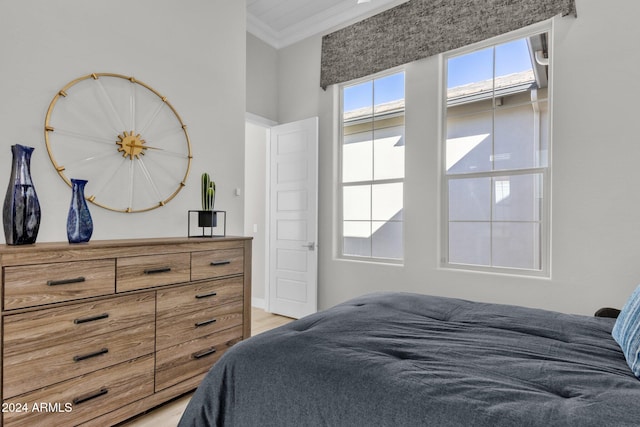 bedroom with light wood-type flooring and ornamental molding