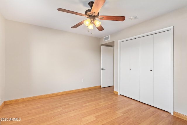 unfurnished bedroom with light wood finished floors, a closet, visible vents, ceiling fan, and baseboards